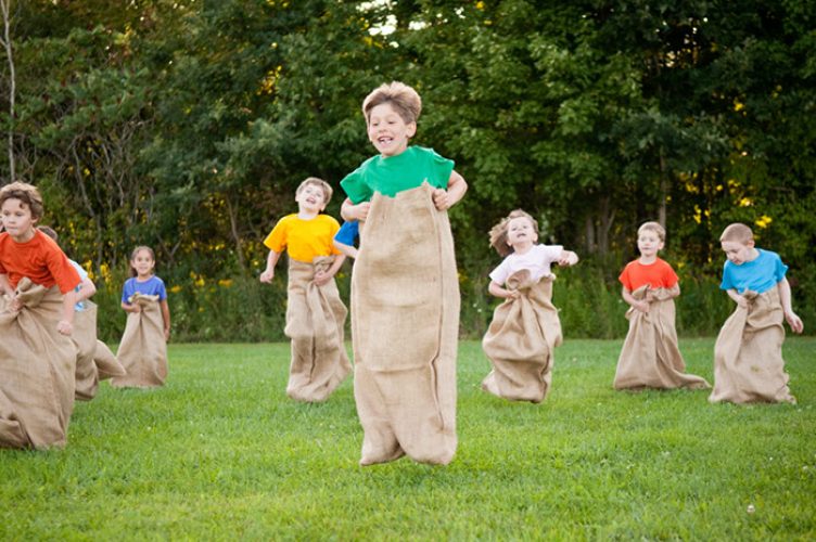 Happy Kids Having Potato Sack Race Outside