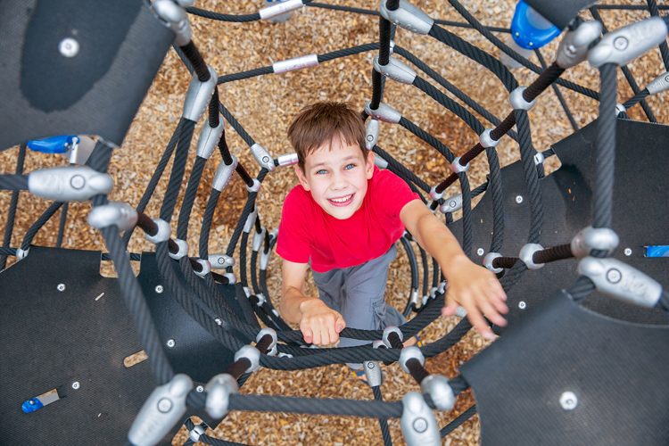 boy climbs up the Jungle Gym. the child having fun on outdoor pl