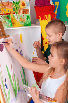 Children painting finger on easel. Group of kids with teacher.
